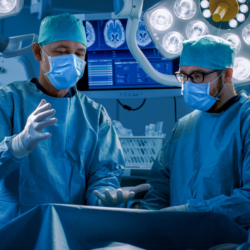 two surgeons wearing masks in an operating theatre